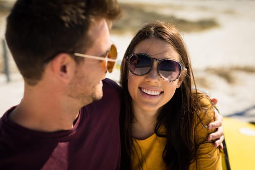 Happy caucasian couple by the sea embracing wearing sunglasses smiling. healthy outdoor leisure time by the sea.