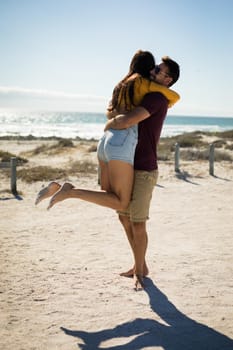 Happy caucasian couple on beach by the sea hugging. healthy outdoor leisure time by the sea.