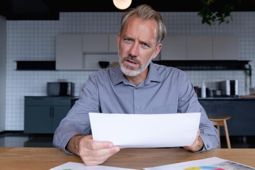 Caucasian businessman sitting having video chat going through paperwork in modern office. business modern office workplace technology.