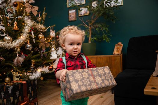 A child holds a gift in his hands. An old Polish tradition of giving gifts during a Christmas feast.