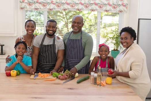 Portrait of happy african american parents with son and daughter and grandparents in the kitchen. three generation family spending quality time together.