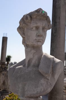 Ancient stone sculpture of man's bust in reclamation yard. art and classical style romantic figurative stone sculpture.