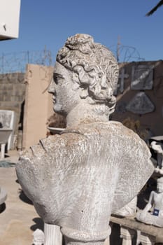 Ancient stone sculpture of man's bust in reclamation yard. art and classical style romantic figurative stone sculpture.