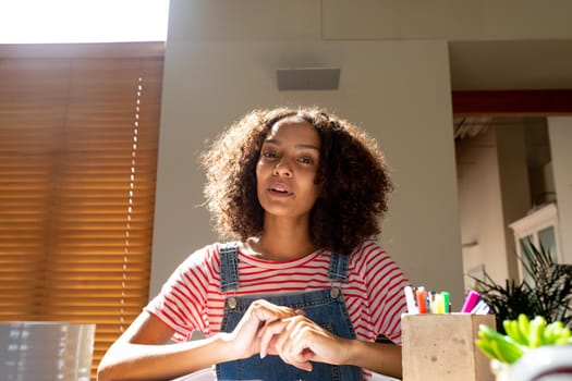 African american businesswoman smiling talking having video call, looking at camera. independent creative design business.