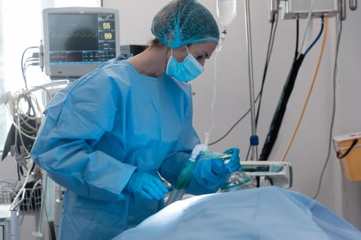 Caucasian female surgeon wearing face mask putting oxygen mask on patient lying in bed. medicine, health and healthcare services during coronavirus covid 19 pandemic.