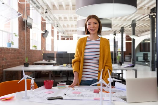 Portrait of asian businesswoman writing and placing memo notes on blueprint. independent creative design business.