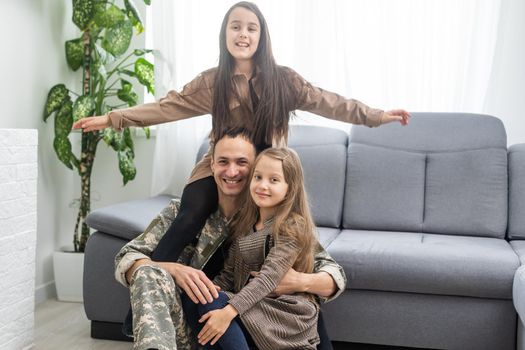 Happy military father and two daughters at home