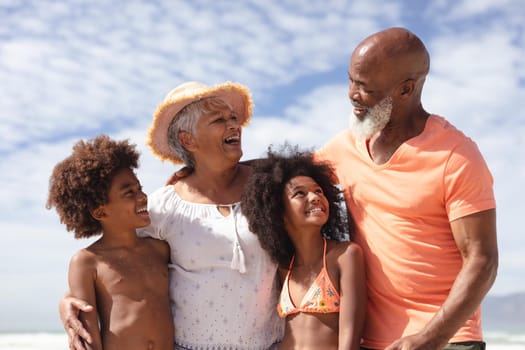 African american grandparents and grandchildren smiling at the beach. travel vacation summer beach holiday concept