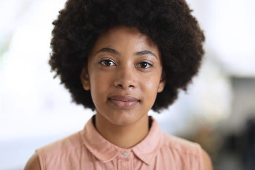 Portrait of african american woman looking at camera and smiling. staying at home in isolation during quarantine lockdown.