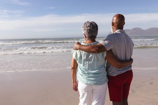 Rear view of senior african american couple hugging each other on the beach. travel vacation retirement lifestyle concept