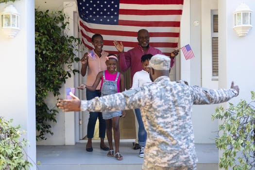 African american soldier father with wife, children and father greeting him outside their house. soldier returning home to family.