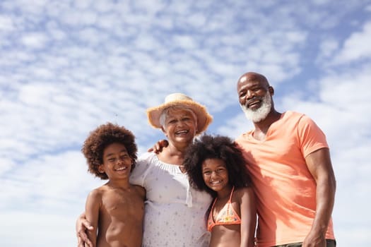 Portrait of african american grandparents and grandchildren smiling at the beach. travel vacation summer beach concept