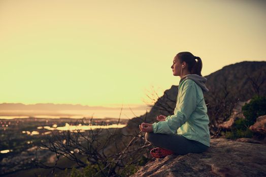 Full length shot of a sporty young woman meditating outdoors.