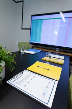 Office table with computer monitor, documents and glasses of water. business items in a modern office.