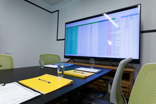 Office table with computer monitor documents and glasses of water. business items in a modern office.