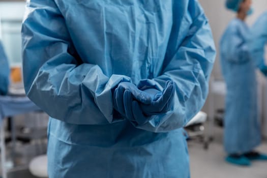 Midsection of doctor wearing surgical overalls and gloves. medicine, health and healthcare services during coronavirus covid 19 pandemic.