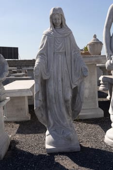 Stone sculpture of virgin mary in reclamation yard. art and classical style romantic figurative stone sculpture.