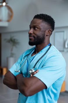 Portrait of african american male doctor with stethoscope wearing scrubs in hospital. medicine, health and healthcare services during covid 19 coronavirus pandemic.