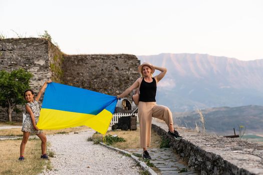 Family of hikers in Ukrainian with Ukrainian flag staying in the mountains