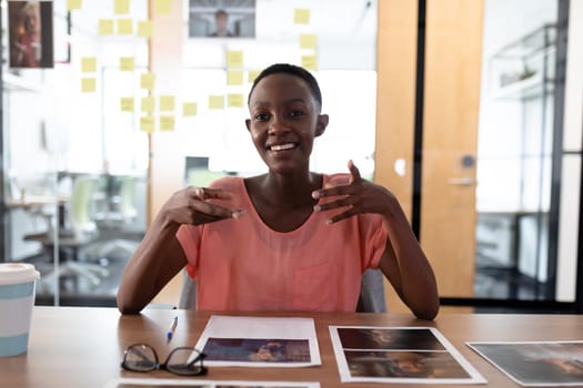 Happy african american businesswoman sitting at desk having video call conversation gesturing. independent creative business