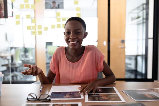 Happy african american businesswoman sitting at desk having video call conversation gesturing. independent creative business