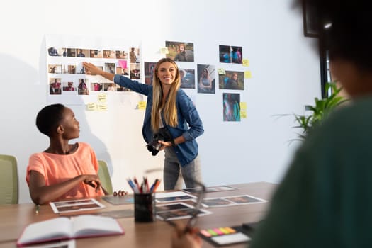 Diverse group of happy business colleagues brainstorming pointing at photos in meeting room. independent creative business in modern office.