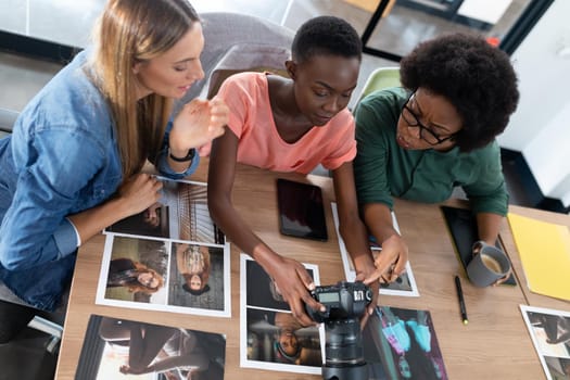 Diverse group of business colleagues brainstorming looking at photos in meeting room. independent creative business.