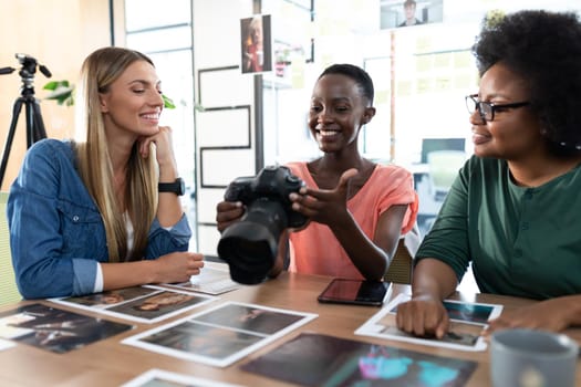 Diverse group of happy business colleagues brainstorming looking at photos in meeting room. independent creative business.