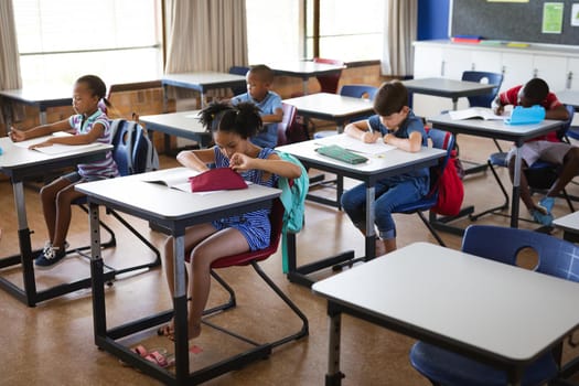 Group of diverse students studying while sitting on their desks in the class at school. school and education concept