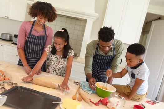 Happy african american couple baking with son and daughter in kitchen. family enjoying quality free time together.