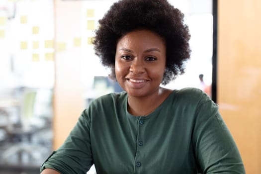 Portrait of african american businesswoman looking to camera and smiling. business person in a modern office.