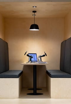 Office desk with microphones, documents, laptop computer, glasses of water and smartphone. business in a modern office.