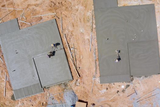 Aerial view of labor using machine application the working polishing scrubbing with concrete cement foundation floor at house under construction site