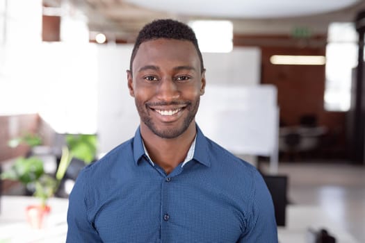 Portrait of african american businessman standing in office smiling to camera. working in business at a modern office.