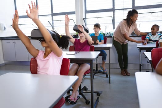 Group of diverse students using electronic devices while sitting on their desk in class at school. school and education concept