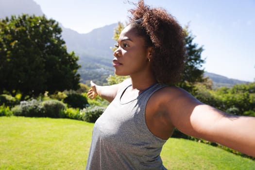 African american woman practicing yoga in sunny garden. active lifestyle, outdoor fitness and leisure time.