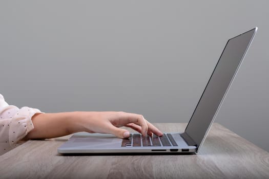 Midsection of caucasian businesswoman using laptop, isolated on grey background. business, technology, communication and growth concept.