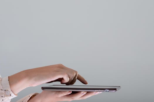 Close up of caucasian businesswoman using tablet, isolated on grey background. business, technology, communication and growth concept.