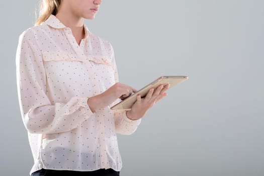 Caucasian businesswoman using digital tablet, isolated on grey background. business, technology, communication and growth concept.