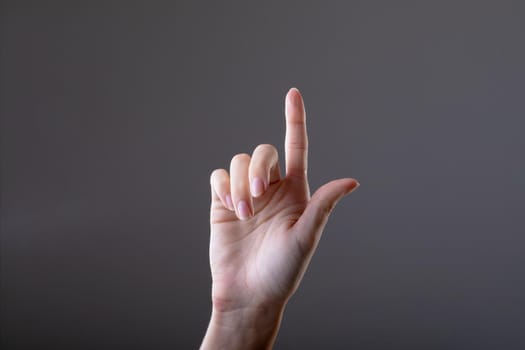 Close up of caucasian businesswoman touching virtual interface, isolated on grey background. business, technology, communication and growth concept.