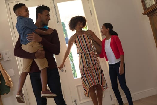 Happy african american couple with son and daughter embracing and smiling at home. family enjoying quality free time together.