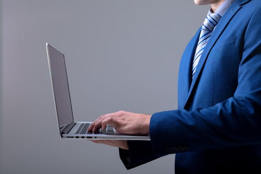 Midsection of caucasian businessman using laptop, isolated on grey background. business technology, communication and growth concept digitally generated composite image.