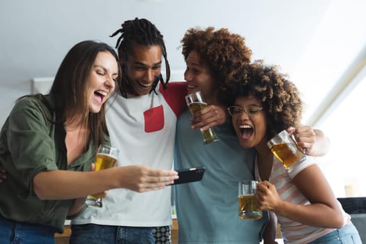 Diverse group of male and female friends looking at smartphone at bar. friends socialising and drinking at bar.