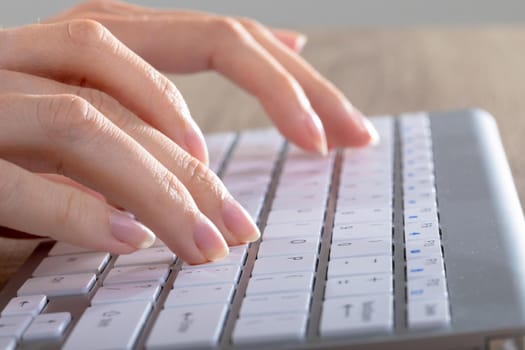 Close up of caucasian businesswoman typing on keyboard, isolated on grey background. business, technology, communication and growth concept.