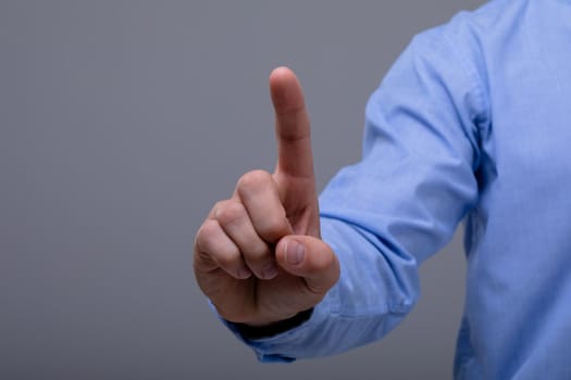 Midsection of caucasian businessman touching virtual interface, isolated on grey background. business technology, communication and growth concept.