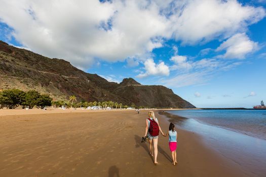 mother and daughter walking on the beach tenerife