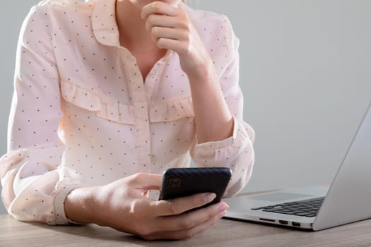 Midsection of caucasian businesswoman using laptop and smartphone, isolated on grey background. business, technology, communication and growth concept.