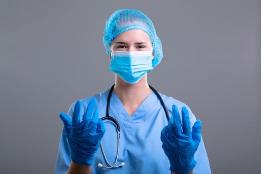 Portrait of caucasian female doctor wearing face mask and medical gloves. medical and healthcare technology concept during covid 19 coronavirus pandemic concept.