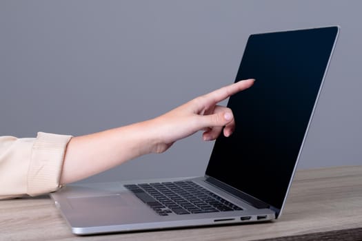 Midsection of caucasian businesswoman using laptop, isolated on grey background. business, technology, communication and growth concept.