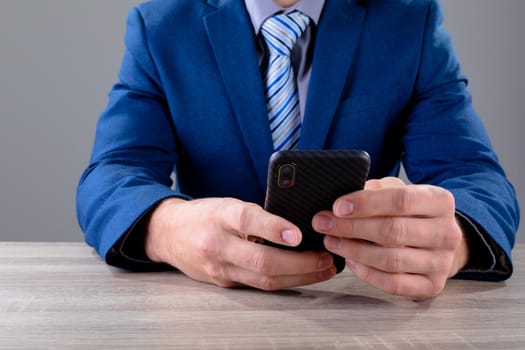 Midsection of caucasian businessman using smartphone, isolated on grey background. business technology, communication and growth concept.